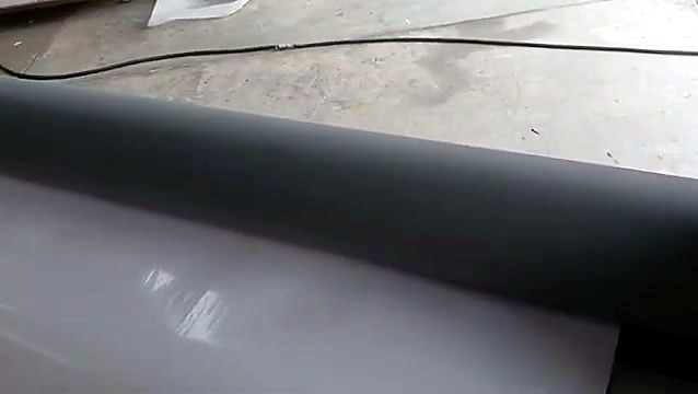 White laminating film running under the black silicone roller
