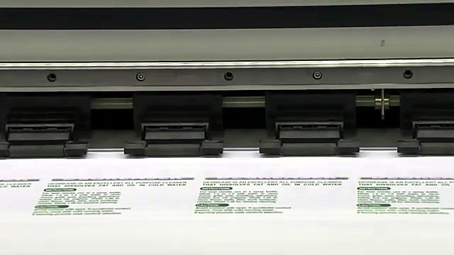 DEGREASER label grid printed on white vinyl roll under pinch rollers (SKU ask)