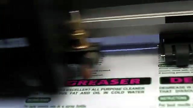 Worker applying printed Degreaser label sheets in warehouse (SKU ask)