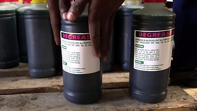 Finished dark Degreaser bottles with magenta labels on pallet (SKU ask)