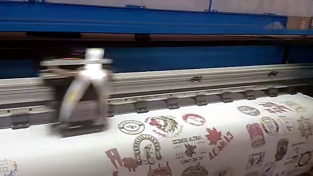 Dense logo sheet advancing on white roll (SKU ask)