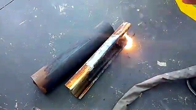LM-V/3000 rust-off with sparks on a steel half-pipe beside a rusty pipe