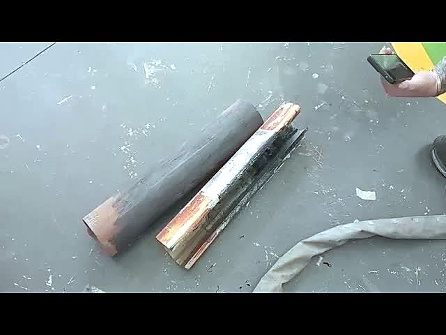 Steel pipe and channel pieces with laser-cleaned bright metal on the workshop floor
