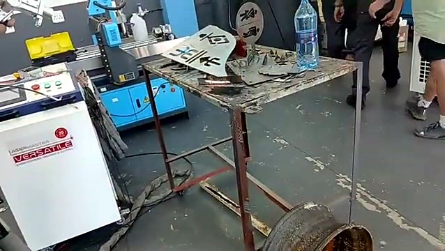 LaserMaster Versatile LM-V/3000 cabinet beside the steel work table with laser-cut parts