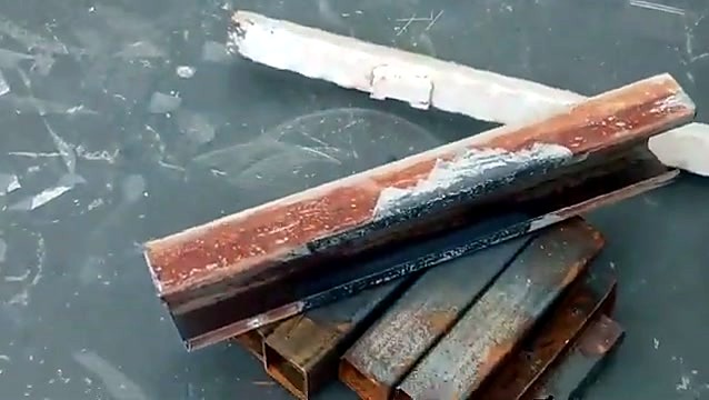 Rusty steel angle with a laser-cleaned bright strip along the seam