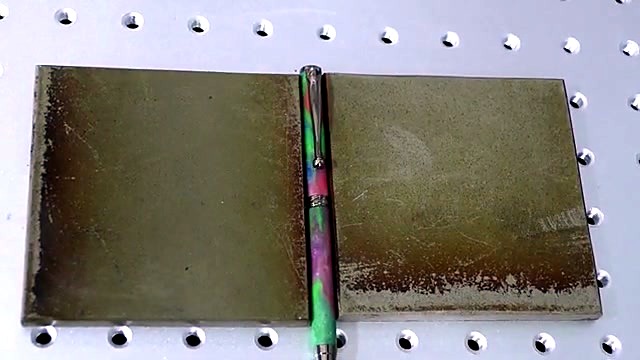 Iridescent pen between temporary metal blocks (SKU ask)