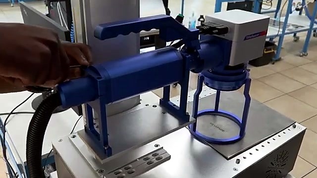 Hand gripping blue handheld unit on stand (SKU ask)