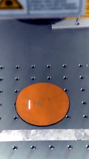 Tan circular leather blank on perforated bed (SKU ask)