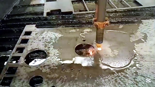 Plasma torch cutting circle in thick plate on water table (SKU ask)