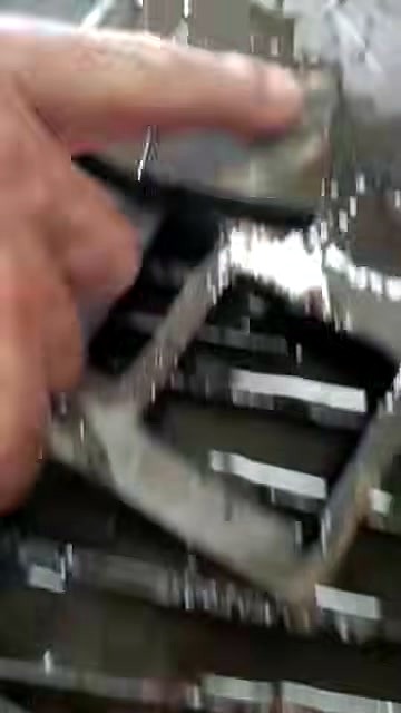 Hand lifting cut metal square from bed (SKU ask)