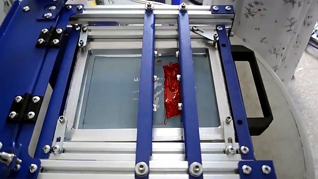 Red ink dollop on mesh in blue/silver screen cradle (SKU ask)