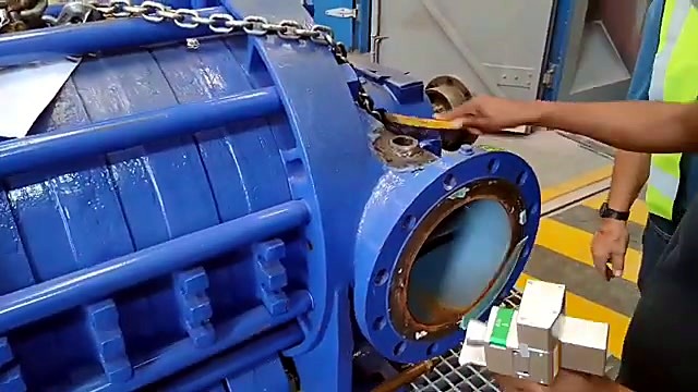 Operator at end flange of blue industrial body (SKU ask)