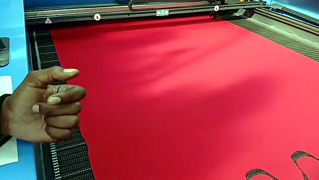 Presenter hand + red fabric laser cutouts on conveyor (SKU ask)