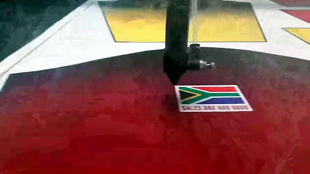 Laser head cutting fabric near SA-flag artwork + AM phone (SKU ask)