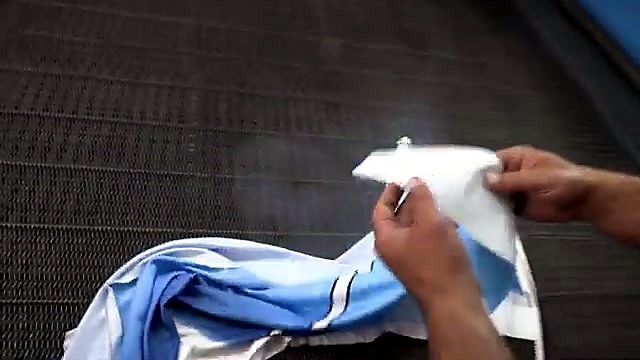 Hands lifting cut fabric off honeycomb/mesh bed (SKU ask)
