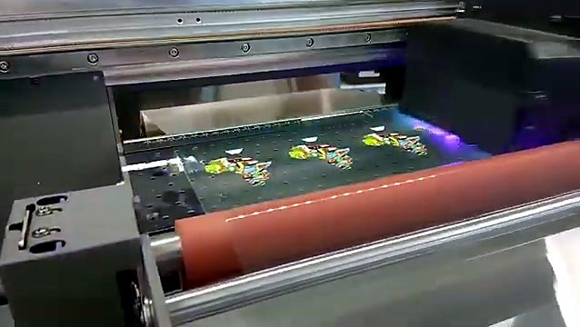 Laminated UV-DTF stickers exiting under the roller