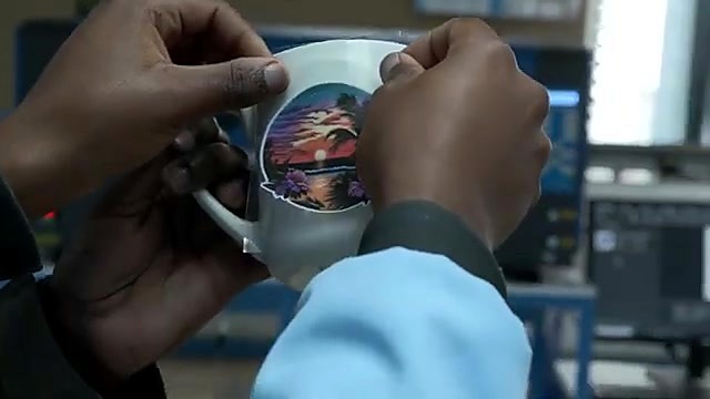 Hands apply circular landscape sticker onto white mug (SKU ask)