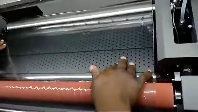 Clear film smoothed on perforated bed under orange roller (SKU ask)