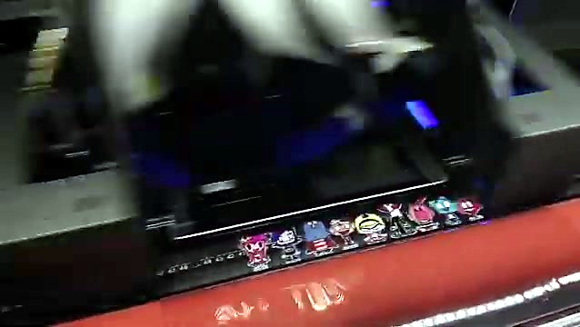 UV-DTF printhead carriage with violet UV glow passing over a row of printed stickers