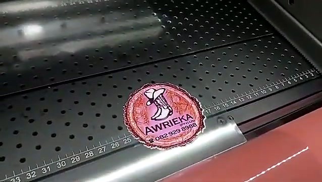 Round full-colour logo sticker printed on UV-DTF adhesive film at the laminator output