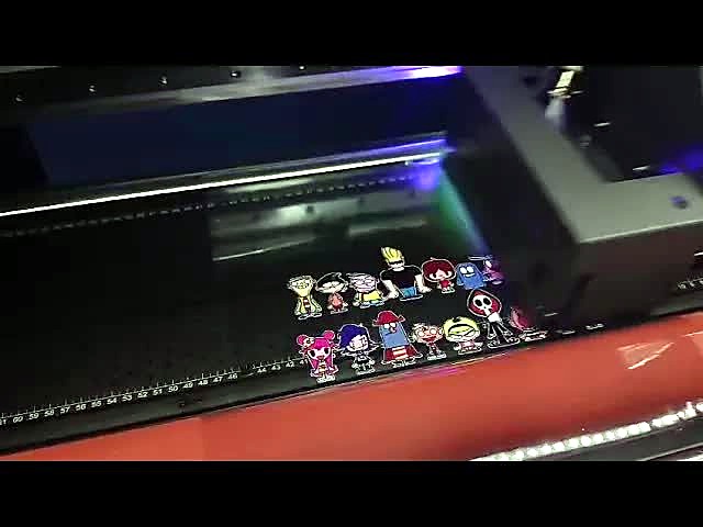 F-UVDTF/600 UV carriage beside freshly printed full-colour cartoon stickers on UV-DTF film