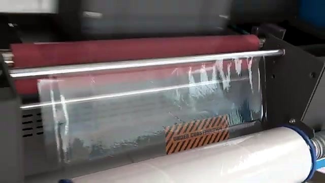 Hazard stripe sticker under clear film through rollers (SKU ask)