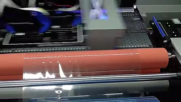 Printed film exiting toward laminate path (SKU ask)