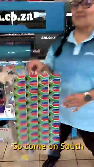 Presenter holding SA flag UV-DTF sticker sheet in showroom (SKU ask)