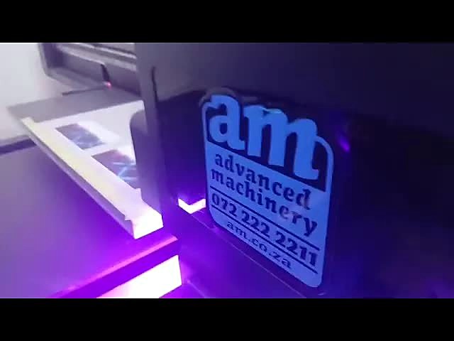 F2-6090C UV printer carriage with am advanced machinery badge under UV light