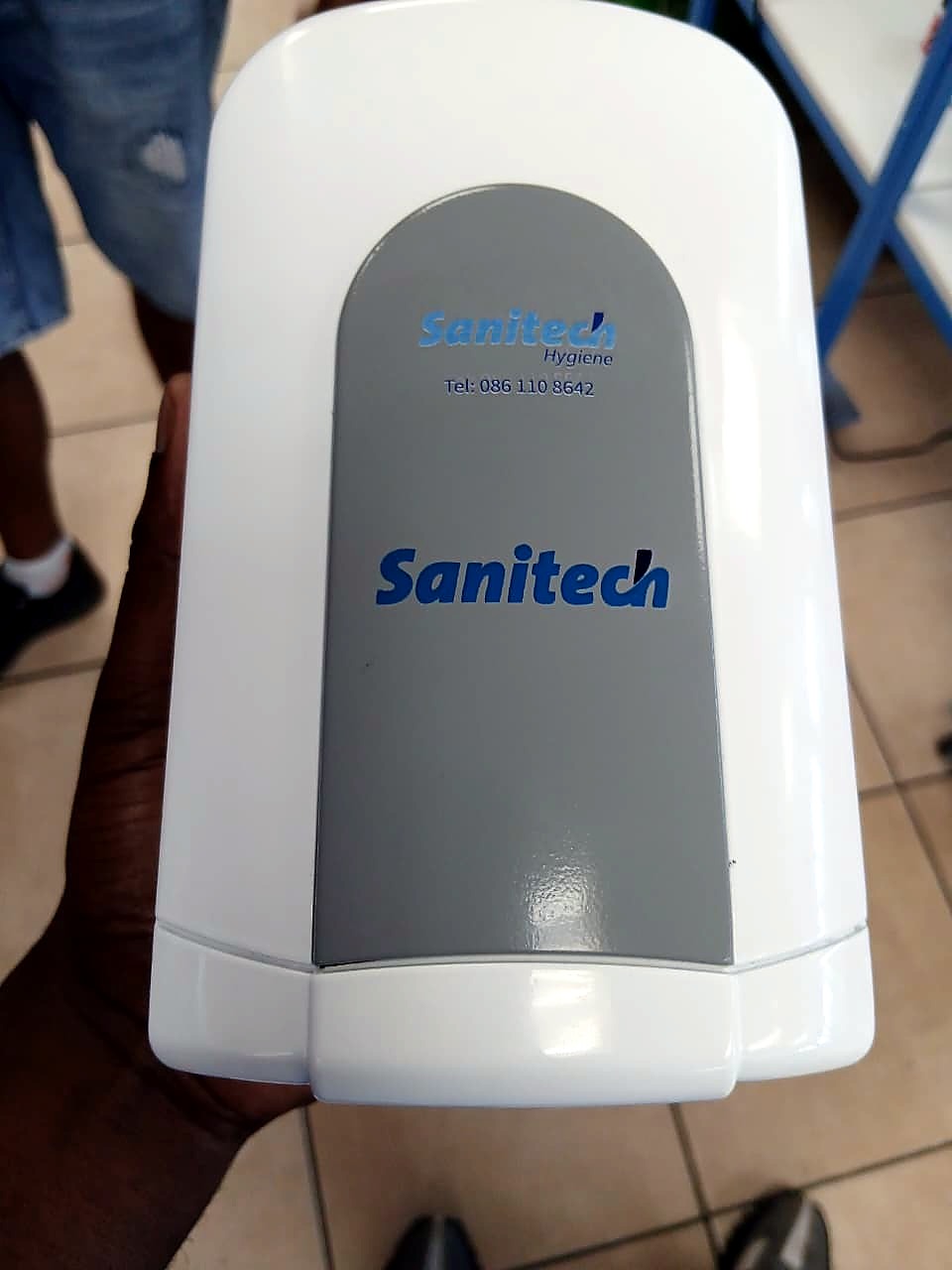F2-6090C UV print: blue Sanitech Hygiene branding on white ABS dispenser cover (staff still)