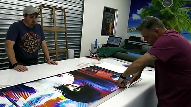 Operators inspect finished canvas on flatbed (SKU ask)