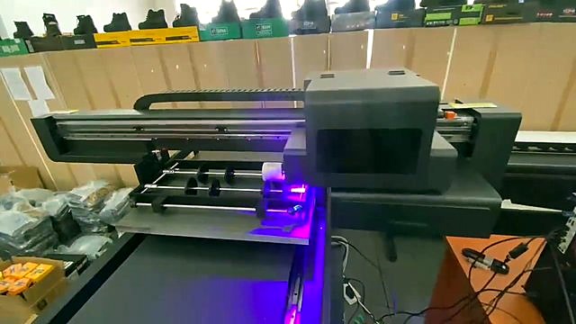 Wide rotary jig on FlatPRINT flatbed during UV pass (SKU ask)