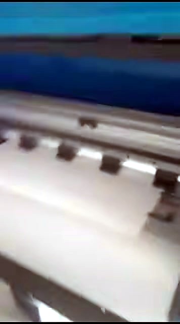 Pinch rollers holding white vinyl under carriage rail (SKU ask)