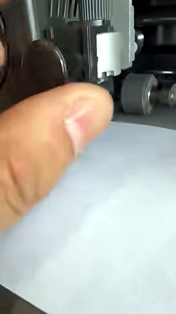 Seated holder in clamp; pinch rollers + rail visible (SKU ask)