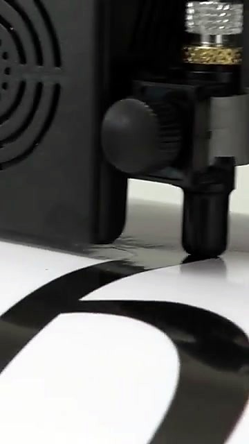 Carriage cutting letterforms on white vinyl (SKU ask)